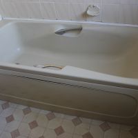 Old bath before removing cupboard and shelf