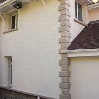Coloured render, stone plinths and sils and splayed window design