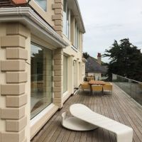 Fitted corner stones, stone sils, k-render front of house and glass balcony